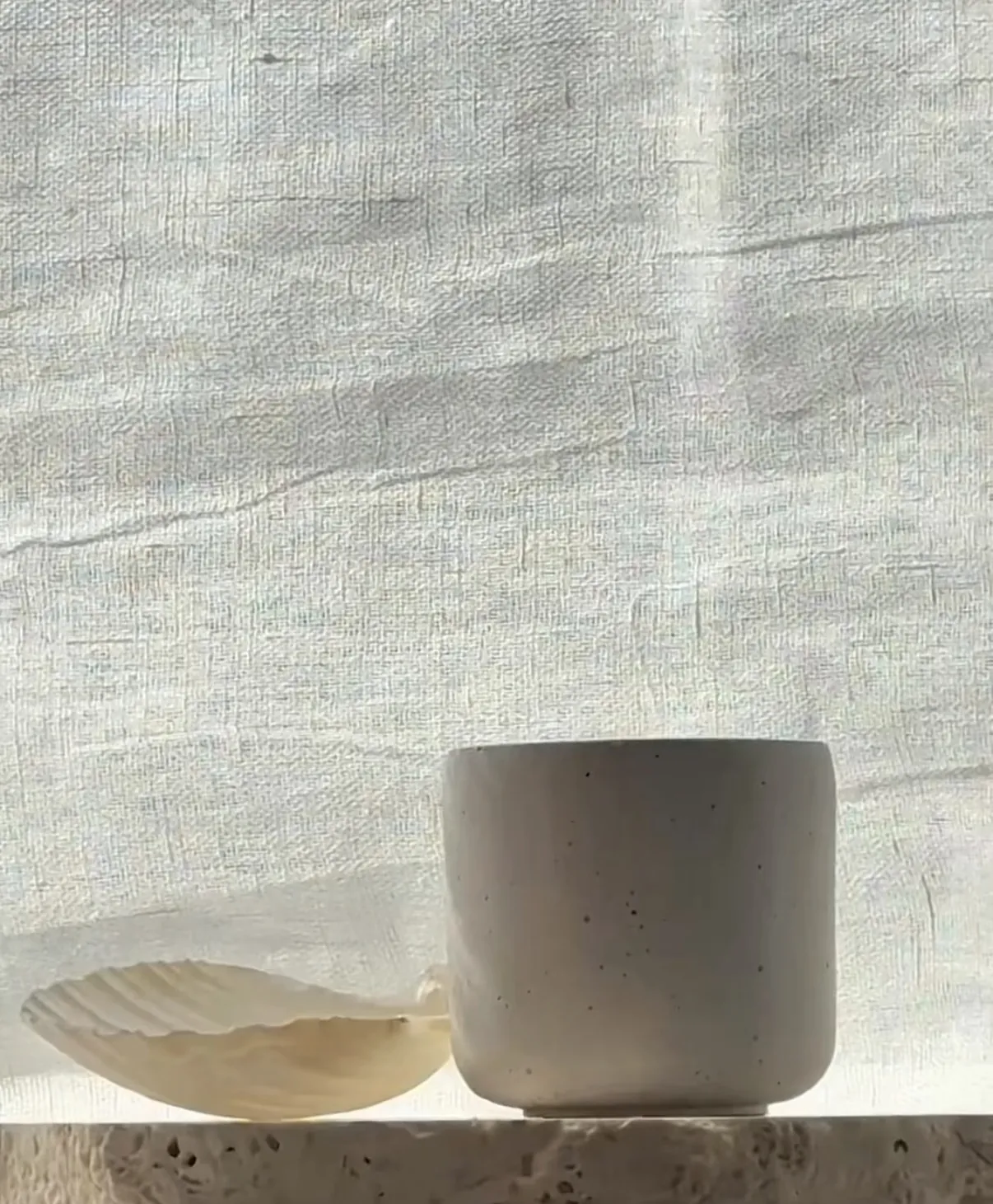 LUER Nº 03 Lune candle in a hand-cast concrete vessel on soft linen